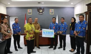 Pj Walikota Asripan Nani Bersama Sunardy Syahid Serahkan Santunan pada Ahli Waris Peserta BPJS Non ASN Kotamobagu